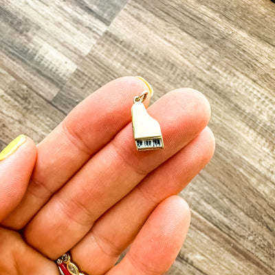 Estate & Vintage 14k yellow gold grand piano charm with black and white enamel keys. Opens up to reveal an enameled red heart