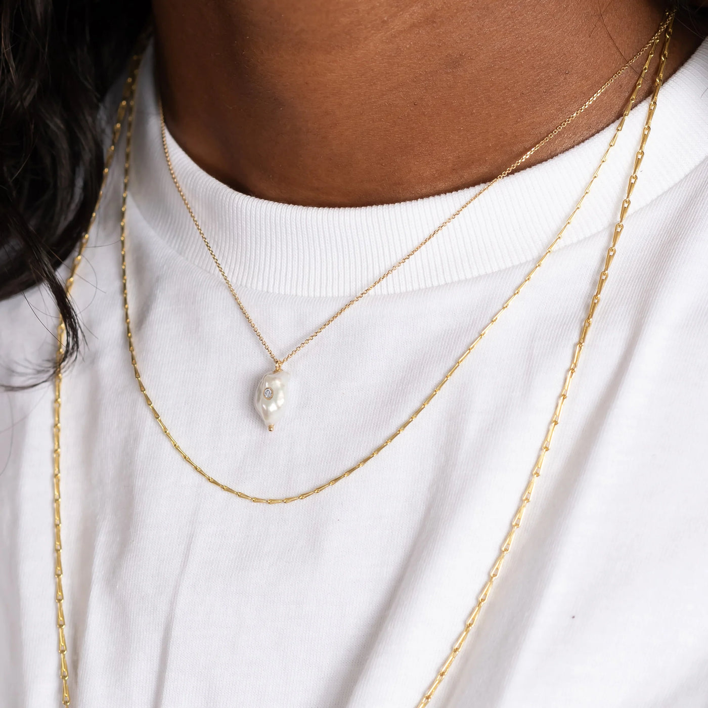 White Space 14k yellow gold necklace with a baroque pearl pendant with a white diamond