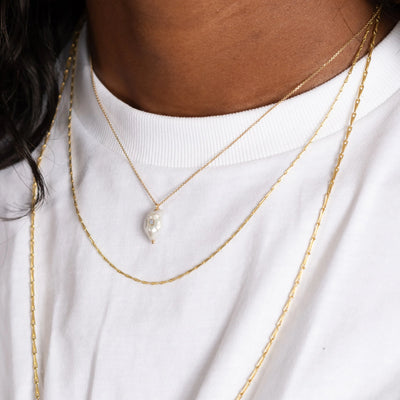 White Space 14k yellow gold necklace with a baroque pearl pendant with a white diamond