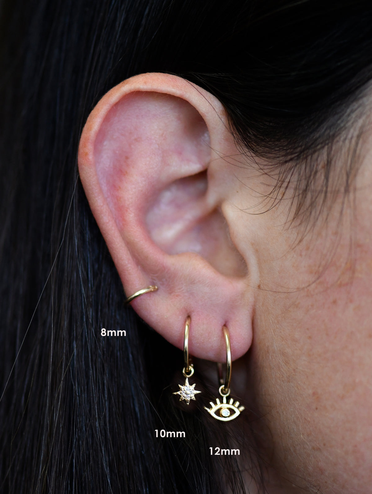 Anzie Mel Soldera evil eye charm set with diamonds suspended from a 14k yellow gold 8mm clicker hoop