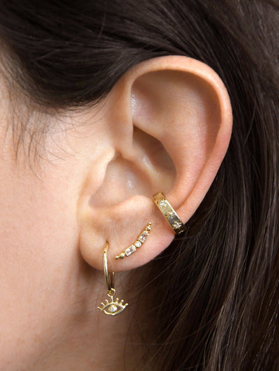 Anzie Mel Soldera evil eye charm set with diamonds suspended from a 14k yellow gold 8mm clicker hoop