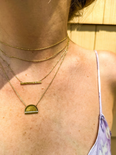 Julez Bryant 14k gold JOKI half dome necklace featuring a single horizontal row of white diamonds.